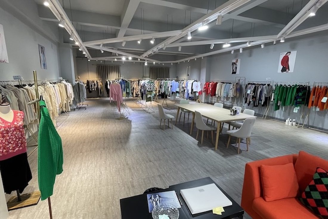 LeMir showroom with seasonal sample racks and buyer meeting table